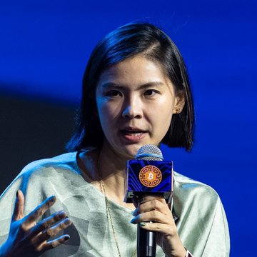Bitget CEO Gracy Chen speaks into a branded microphone, conveying her lack of optimism about recovering the $388 million stolen in the exchange's recent breach. Her serious expression and hand gesture underscore the gravity of her statement, which referenced the 2025 Bybit hack's low recovery rate of just 3.5% as a cautionary comparison.