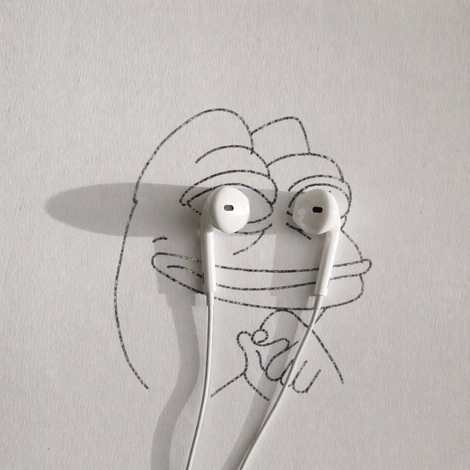 A child's pencil sketch of a smiling face is shown with white Apple EarPods placed over the eyes, casting shadows on the paper, playing on the "to the moon" cryptocurrency meme.