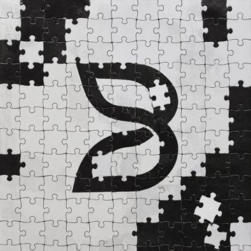 A black and white jigsaw puzzle pattern with a large stylized 'B' symbol in the center, resembling the Binance logo.