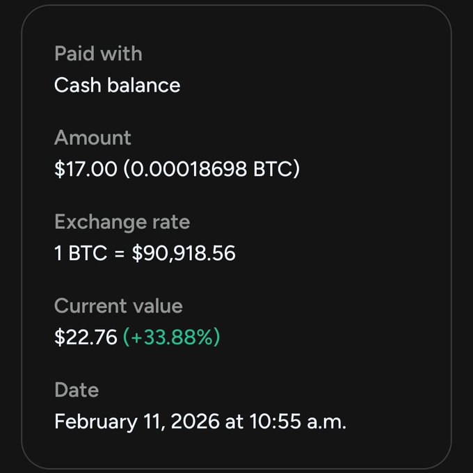 A dark payment receipt showing a Bitcoin purchase: Paid with Cash balance, Amount $17.00 (0.00018698 BTC), Exchange rate 1 BTC = $90,918.56, Current value $22.76 (+33.88%), dated February 11, 2026 at 10:55 a.m.
