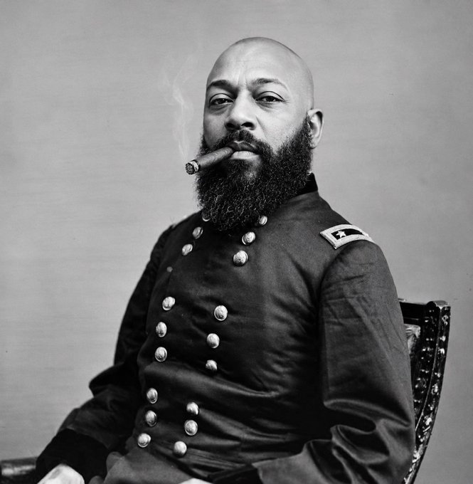 A black-and-white portrait shows a bearded, bald man in a double-breasted military uniform with a star shoulder insignia, casually smoking a cigar while seated in an ornate chair. The image ties to the post's carefree, confident theme—evoking the "main character energy" of someone unfazed by a random Solana giveaway draw.

No text, numbers, or tickers are visible in the image itself.