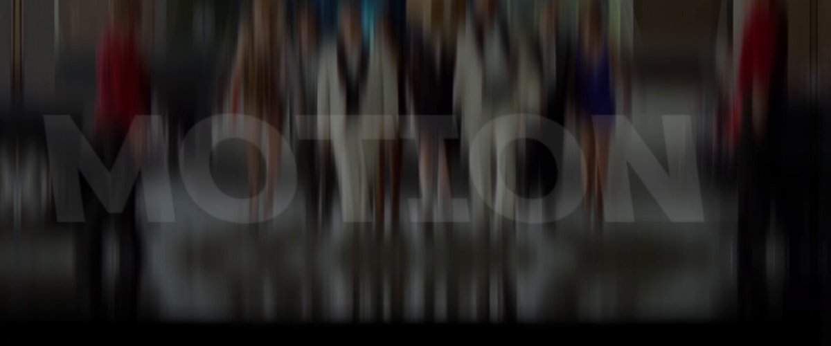 The image shows a blurred group of people walking down a street, with the word "motion" written above them. The focus of the photo appears to be on the motion of the people rather than their individual features or expressions. This creates an interesting visual effect that draws attention to the concept of movement and its connection to the post's title.