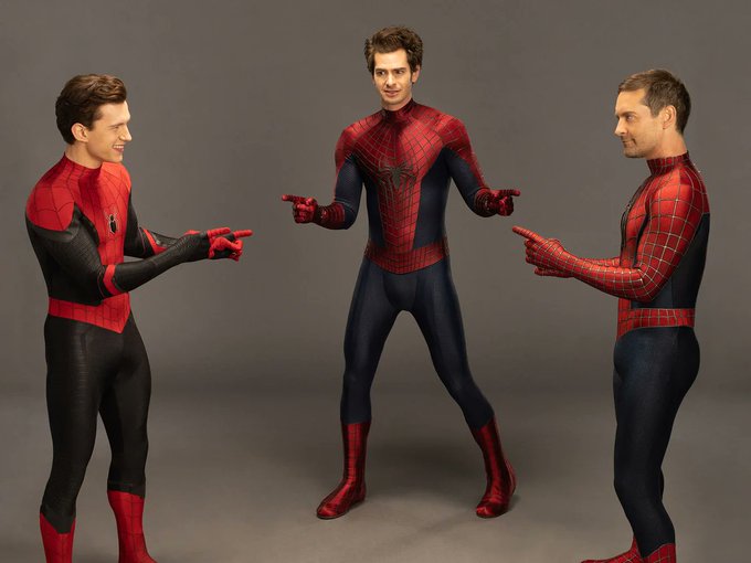 Three actors who have played Spider-Man - Tom Holland, Andrew Garfield, and Tobey Maguire - in their Spider-Man suits pointing at each other in the famous meme pose.