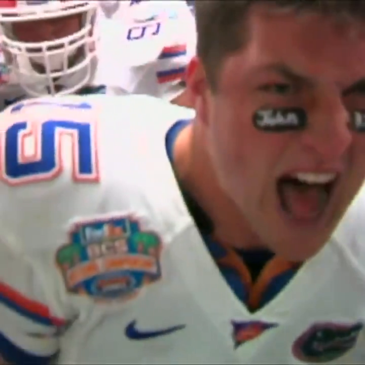 A close-up of an excited Florida Gators football player wearing eye black, screaming in celebration, with a teammate wearing jersey number 5 visible in the background.