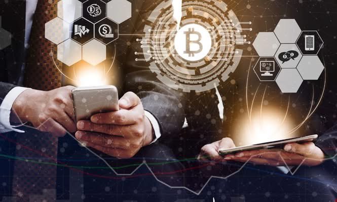 A businessman in a suit holds a smartphone while digital Bitcoin icons, hexagonal graphics, and financial charts overlay the scene, suggesting cryptocurrency trading.