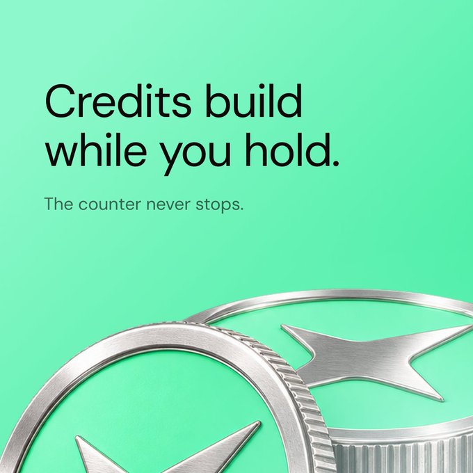 The image features a mint green background with bold black text reading "Credits build while you hold." accompanied by the subtext "The counter never stops." in a lighter font, while two large silver coins embossed with star designs peek into the frame from the bottom, visually reinforcing the post's announcement that the Perk Credit tracker has gone live for $PERK holders, symbolizing the continuous accumulation of credits for both large and small token balances.