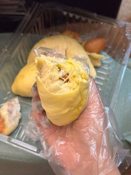 The image shows a person holding a yellow food item, possibly a sandwich or a wrap, with their hand. The background of the photo features a green tablecloth, which contrasts with the yellow color of the food. There are also other food items in the scene, including a donut and some bread. The post appears to be related to cryptocurrency, as it contains text that reads "Crypto Survival Plan" followed by an image of a person holding a sandwich or wrap.