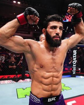 A shirtless UFC fighter with a beard raises his arms in victory inside the octagon, with "UFC" visible on his shorts and "crypto.com" branding on the cage. The image of the victorious fighter relates to the post announcing Arman Tsarukyan's return to the Octagon for the UFC 331 co-main event on September 19.