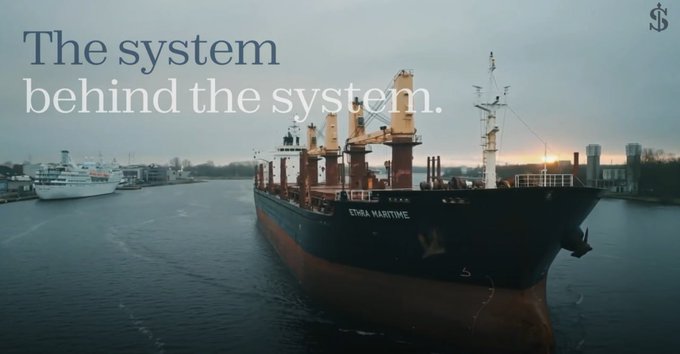 A large cargo ship named 'CHINA MARITIME' docked in a harbor at sunset, with text overlay reading 'The system behind the system.'