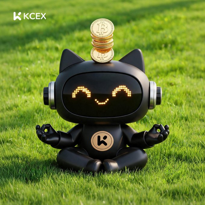 A promotional image featuring a black cat-shaped robot with a smiling LED face, sitting in meditation pose with Bitcoin coins balanced on its head, set against a green grass background with the 'KCEX' logo in the top left.
