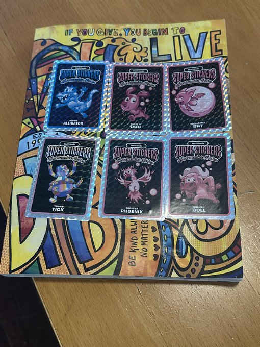 Six 'Super Stickers' collectible cards featuring characters named Alligator, Dog, Bat, Tick, Phoenix, and Bull are arranged on top of a colorful 'LIVE' themed binder page.