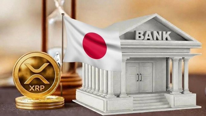 A golden XRP cryptocurrency coin is displayed alongside a model of a bank building and a Japanese flag, suggesting a connection between XRP and Japanese banking.