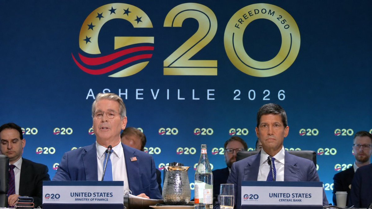 U.S. Treasury Secretary Scott Bessent and Federal Reserve officials sit at the "United States Ministry of Finance" and "United States Central Bank" nameplates during a G20 Finance Ministers summit in Asheville 2026, with the "Freedom 250" G20 logo displayed behind them. The image visually supports the post's reference to Bessent releasing the G20 Chair's Statement addressing digital currency policy among finance leaders.