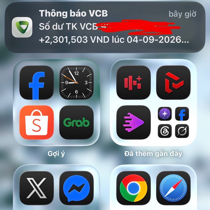 An iPhone home screen showing a VCB bank notification in Vietnamese indicating a balance change of +2,301,503 VND dated 04-09-2026, with app icons including Facebook, Grab, X (Twitter), Messenger, Chrome, and Safari.