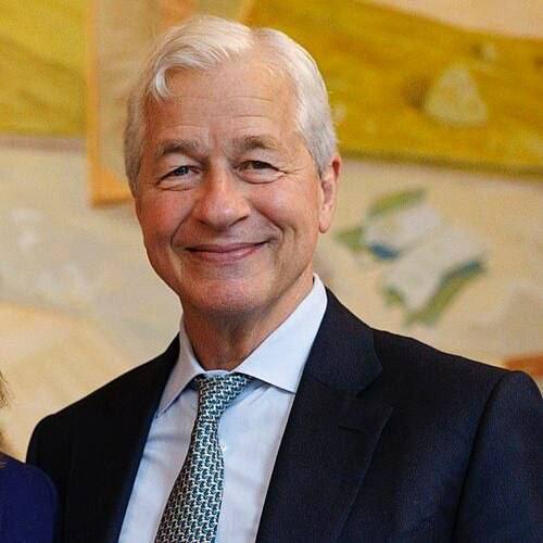 The image shows an older man with silver hair, wearing a dark suit, light blue shirt, and a patterned tie, smiling at the camera. Based on the context, this appears to be Jamie Dimon, the JPMorgan CEO referenced in the accompanying opinion piece about Gen Z needing flexibility in their careers.