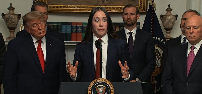 A woman in a dark suit and red tie speaks at a podium bearing the Presidential Seal, flanked by several officials including a man in a red tie on the left, with bookshelves and an American flag in the background. The energetic "SEND IT ALL AND SEND IT NOW" caption reflects the speaker's animated, hands-raised gesture as she appears to passionately address an audience.