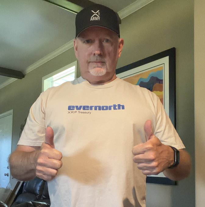 A man wearing an "ARMY" cap and an "evernorth XRP Treasury" t-shirt gives two thumbs up, looking ready for the trail as suggested by the post "It's time to go touch the trails."