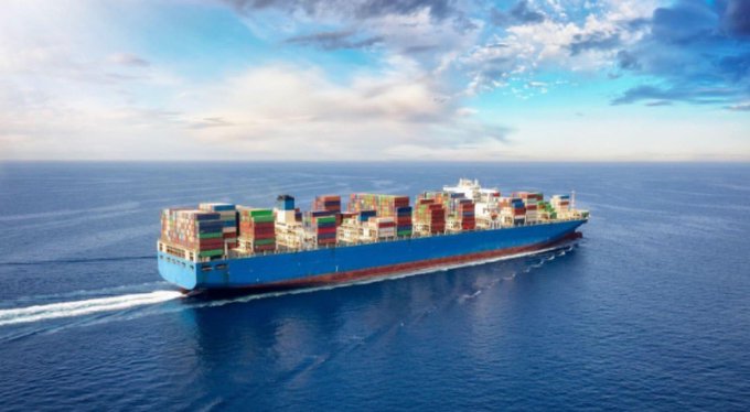 A massive blue container ship loaded with colorful shipping containers sails across open ocean waters, illustrating real-world maritime commerce that the post connects to @EthraShip's blockchain infrastructure built around dry bulk vessel operations backed by Ethra Invest.