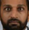 A low-resolution cropped image showing the face of a man with a beard.