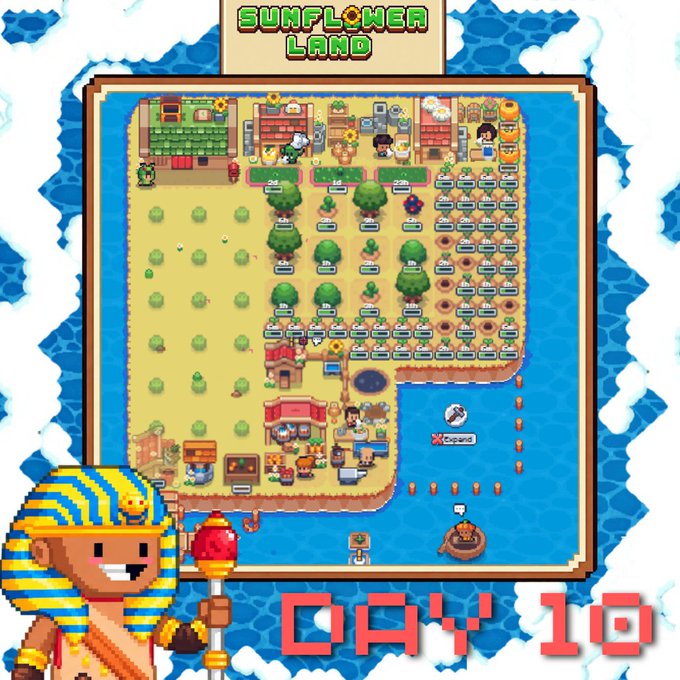 A screenshot of a pixel art video game titled 'SUNFLOWER LAND,' displaying 'DAY 10' at the bottom. The scene shows various characters, crops, sunflowers, and buildings on a landmass surrounded by water, with an Egyptian-themed character holding a staff in the foreground.