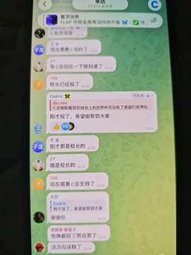 A smartphone displays a Chinese-language Telegram group chat discussing the "FLAP" token, with users celebrating that the team has supported their community and helped maintain the token's price. The visible messages reference community efforts, voting, and thanks to officials like "C Zong," aligning with the post's message about defending against malicious whales and acknowledging official support.