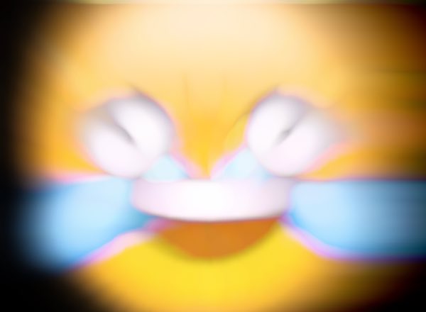 A heavily blurred, distorted image featuring yellow and blue colors with a symmetrical, mirrored visual effect, making the subject unrecognizable.