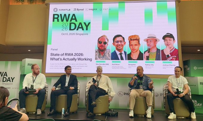 A panel discussion takes place at "RWA DAY 2026" in Singapore, featuring five men seated on stage under a screen displaying the topic "State of RWA 2026: What's Actually Working" alongside the logos of Mantle, Byreal, InsightX, and PWTAGE.
