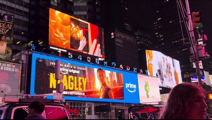 A nighttime view of Times Square featuring illuminated billboards, including a prominent Amazon Prime Video advertisement for the series "The Runarounds" displaying "1540 BROADWAY" and "WEDNESDAY | SEPTEMBER 17".