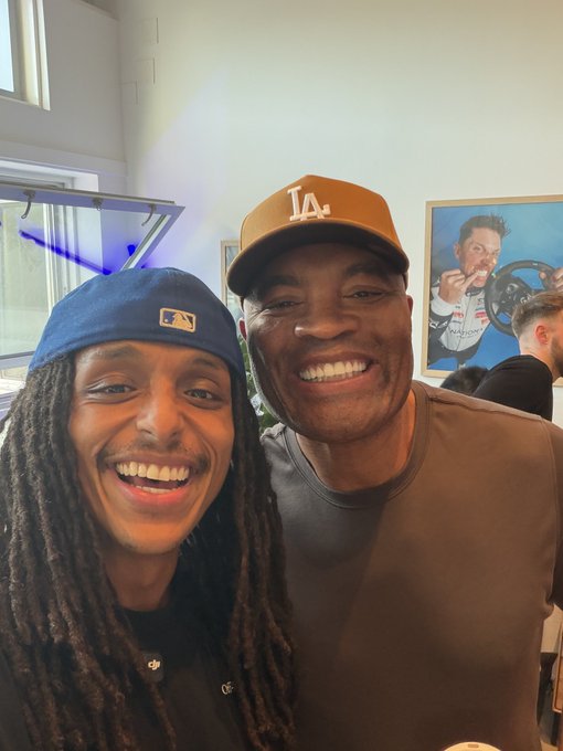 Two people pose for a smiling selfie, one wearing a blue MLB cap and the other sporting an orange "LA" Dodgers hat. The caption notes they met "one of the GOATs @SpiderAnderson," suggesting a fan encounter with the comedian.