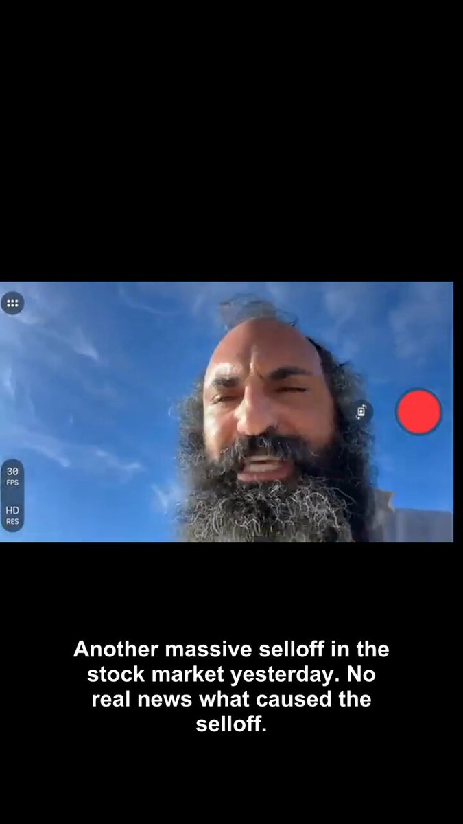 The image shows a man with a very long beard wearing glasses looking directly at the camera as if posing for a picture. A caption below the photo states that another massive selloff hit the stock market, causing Bitcoin to pull back into its trade. The context suggests that this might be related to an article or news post about the current economic situation involving Bitcoin and other stocks.