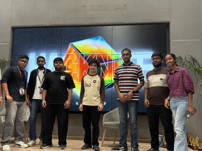 Seven people pose in front of a large screen displaying the colorful "NEXT GEN" logo, representing the winning projects from the Algorand x402 hackathon organized by Algo Bharat. The group appears to be the developers or representatives of the winning teams celebrating their achievement at the event.