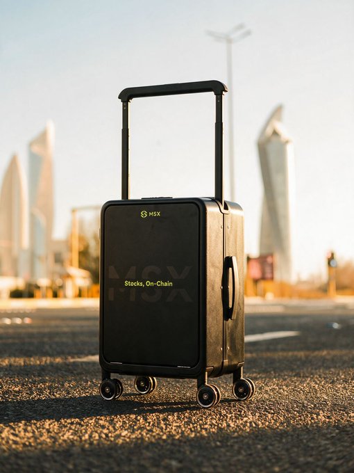 A sleek black MSX-branded suitcase sits on an open road with city buildings in the background, promoting a giveaway in partnership with Maitong (@MSX_CN) where winners can receive travel gear and US stock tokens including 10U of $NVDA.