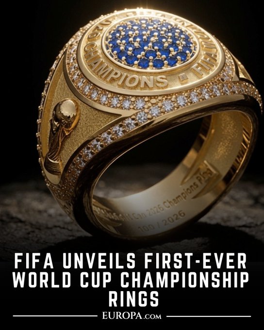 A close-up image of an ornate gold championship ring with blue gemstones and diamond accents, captioned 'FIFA UNVEILS FIRST-EVER WORLD CUP CHAMPIONSHIP RINGS' with Europa.com branding.