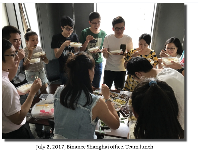 A photograph dated 'July 2, 2017, Binance Shanghai office. Team lunch.' showing a diverse group of colleagues gathered around a table eating together.