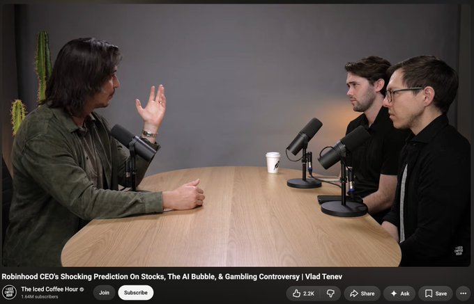 Podcast interview scene from 'The Iced Coffee Hour' featuring Vlad Tenev, with title 'Robinhood CEO's Shocking Prediction On Stocks, The AI Bubble, & Gambling Controversy'. Three people sit around a wooden table with microphones.