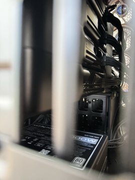 The image shows the interior of a computer case, featuring a graphics card and tangled cables, with the caption "A mind behind bars" using the case's vertical metal bars as a visual metaphor for the internal hardware challenges of temperature and noise management described in the post.