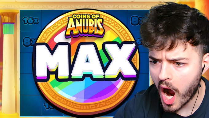 A streamer with a shocked expression reacts excitedly as a "MAX" coin appears on the screen of the slot game "Coins of Anubis," highlighting the max win moment mentioned in the video's announcement.
