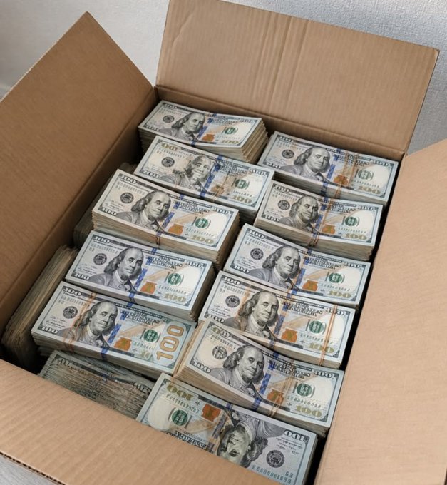 A cardboard box filled with numerous neatly stacked bundles of US $100 bills.