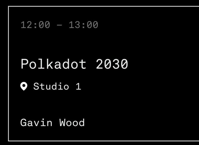The image shows a black and white photo of a sign with text that reads "Polkadot 2030 Studio 1". The time displayed on the sign is 12:00 - 13:00, indicating that the studio will be open at this time.