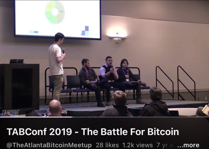A video thumbnail titled 'TABConf 2019 - The Battle For Bitcoin' showing a panel discussion on stage with speakers and a chart projected on a screen.