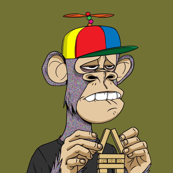 A cartoon illustration of a sad-looking monkey wearing a colorful propeller cap while holding a small wooden structure.
