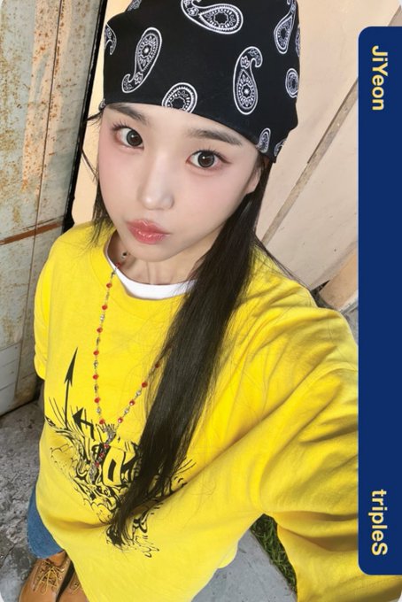 A selfie of a young woman wearing a yellow graphic sweatshirt and a black paisley bandana, with 'JiYeon' and 'triples' written on a blue side bar.
