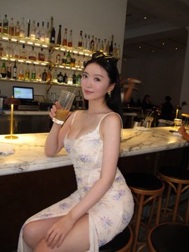 A woman in a floral dress poses with a drink at a bar, checking in at a trendy brunch spot in a style reminiscent of Jennie, while promoting a 5% cashback offer with BitMart card hashtags #BitMartcard #web3 #u卡.