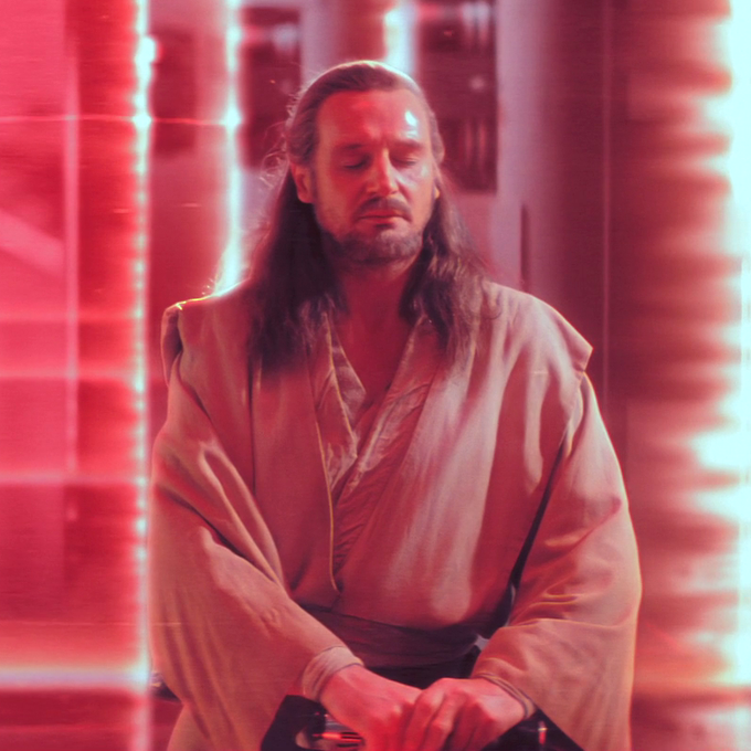 A cinematic still features a man with long hair and a beard wearing tan Jedi robes, seated with his eyes closed against a glowing red background.