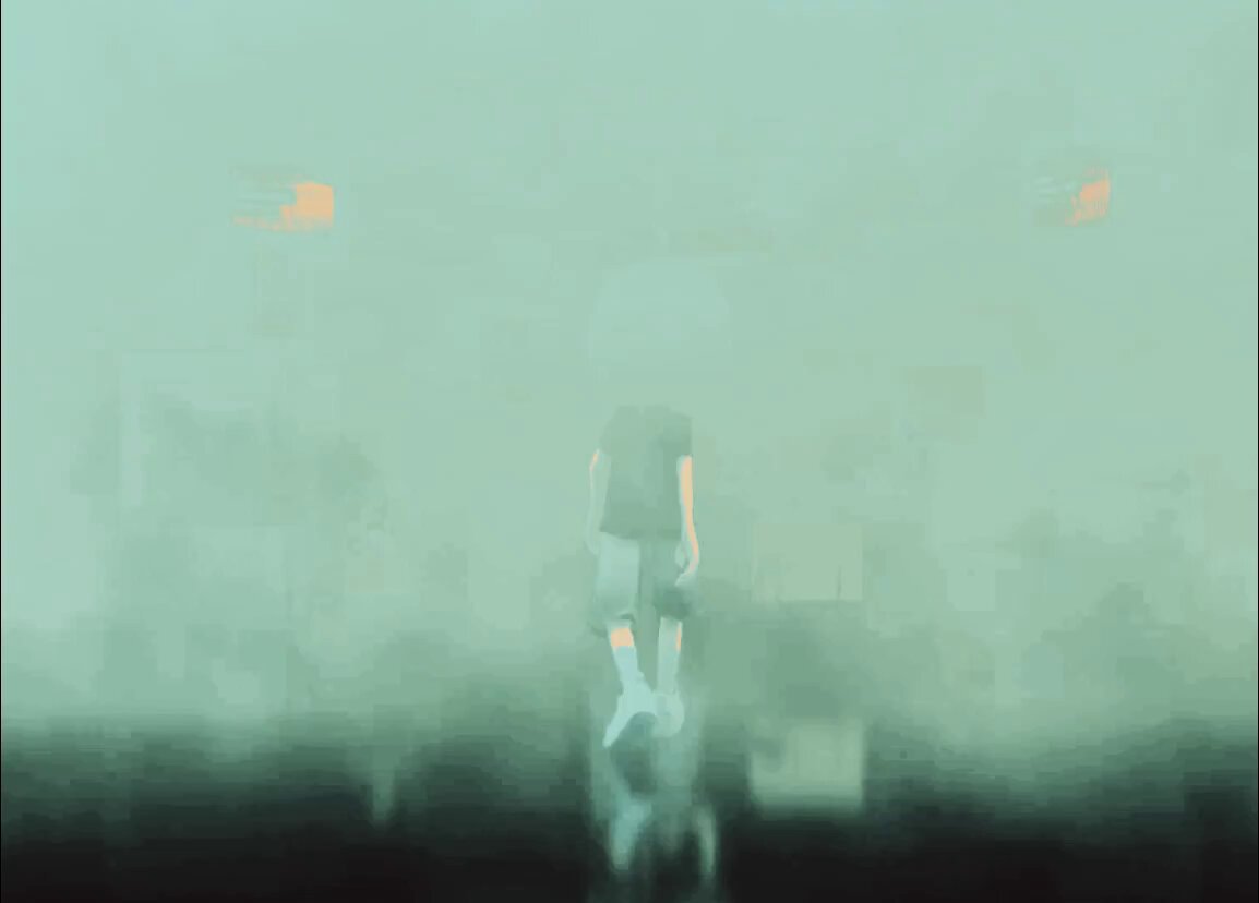 The image features a man standing in front of two buildings, one of which has an orange light on top. The background appears to be foggy or misty, creating a somewhat mysterious atmosphere around the scene. There are no discernible texts present in the image, and the focus is primarily on the man and his surroundings.