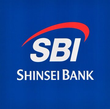 The image displays the SBI Shinsei Bank logo, featuring white "SBI" and "SHINSEI BANK" text alongside a red curved accent on a blue background. This relates to the post as SBI Group is poised to launch its lending service for JPYSC, Japan's first trust bank-backed yen stablecoin offering a 3% annual yield.