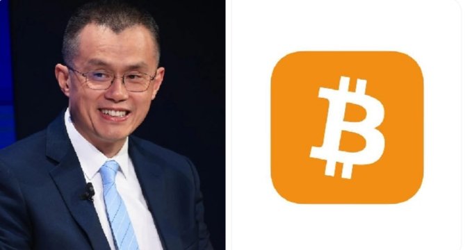 The image features a man wearing glasses and a suit standing next to an orange square with the word "bitcoin" written inside of it. The man appears to be smiling, possibly posing for a photo or giving a speech related to Bitcoin.