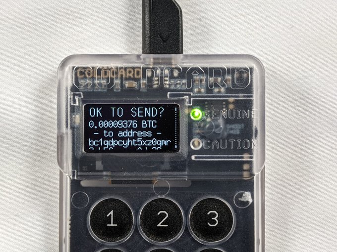 A close-up photo of a Coldcard hardware wallet showing its small screen displaying "OK TO SEND? 0.00009376 BTC - to address - bc1qdpcfyt5x2..." along with a green indicator light and numeric buttons. The image visually represents the Coldcard device mentioned in the post, which warns users of a major security vulnerability affecting this specific hardware wallet for storing Bitcoin.