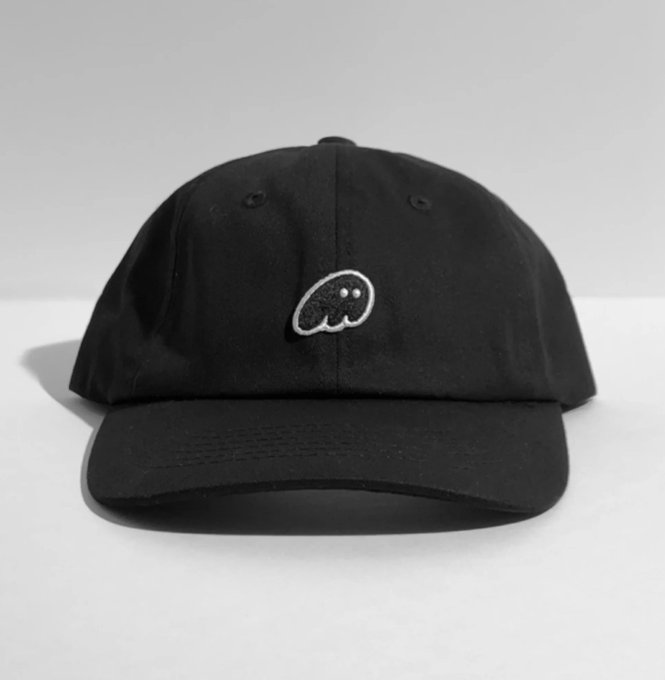A black baseball cap featuring a small embroidered ghost logo on the front, presented as Phantom's "cure" for crypto pattern baldness in a humorous meme-style advertisement.