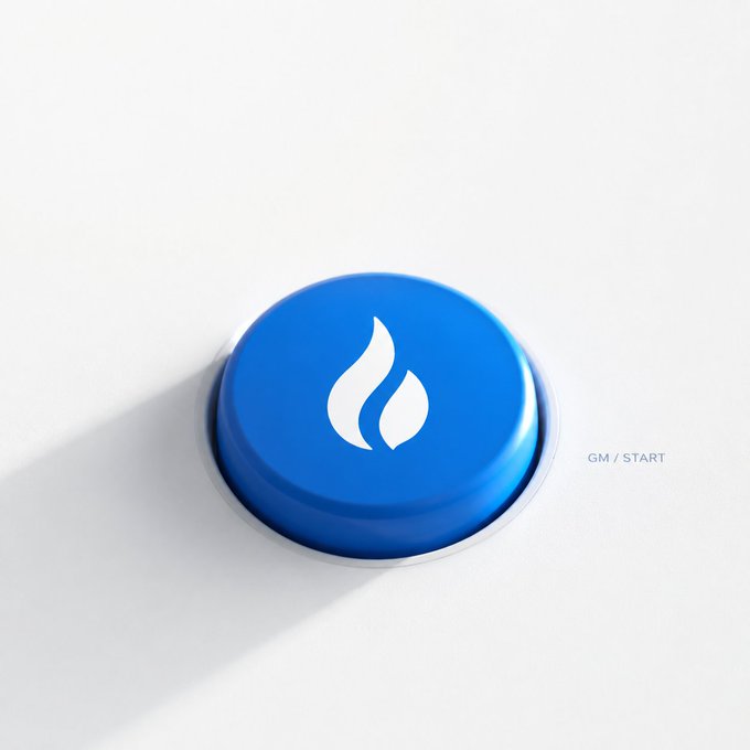 A glossy blue button with a white flame icon sits on a light background, with "GM / START" written to its right, representing the "GM" (Good Morning) crypto greeting and symbolizing the start of a new week for trading U.S. stocks on the Huobi platform.